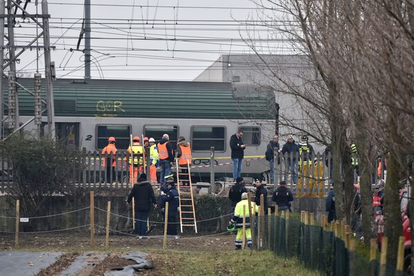 Спасатели и полицейские на месте крушения поезда на окраине Милана, Италия. 25 января 2018 года