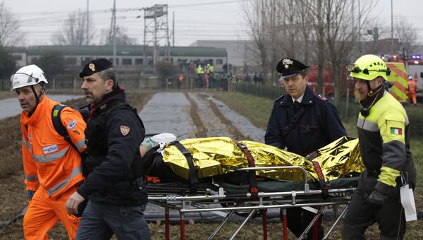 Спасатели и полицейские везут пострадавшего на месте крушения поезда на окраине Милана, Италия. 25 января 2018 года