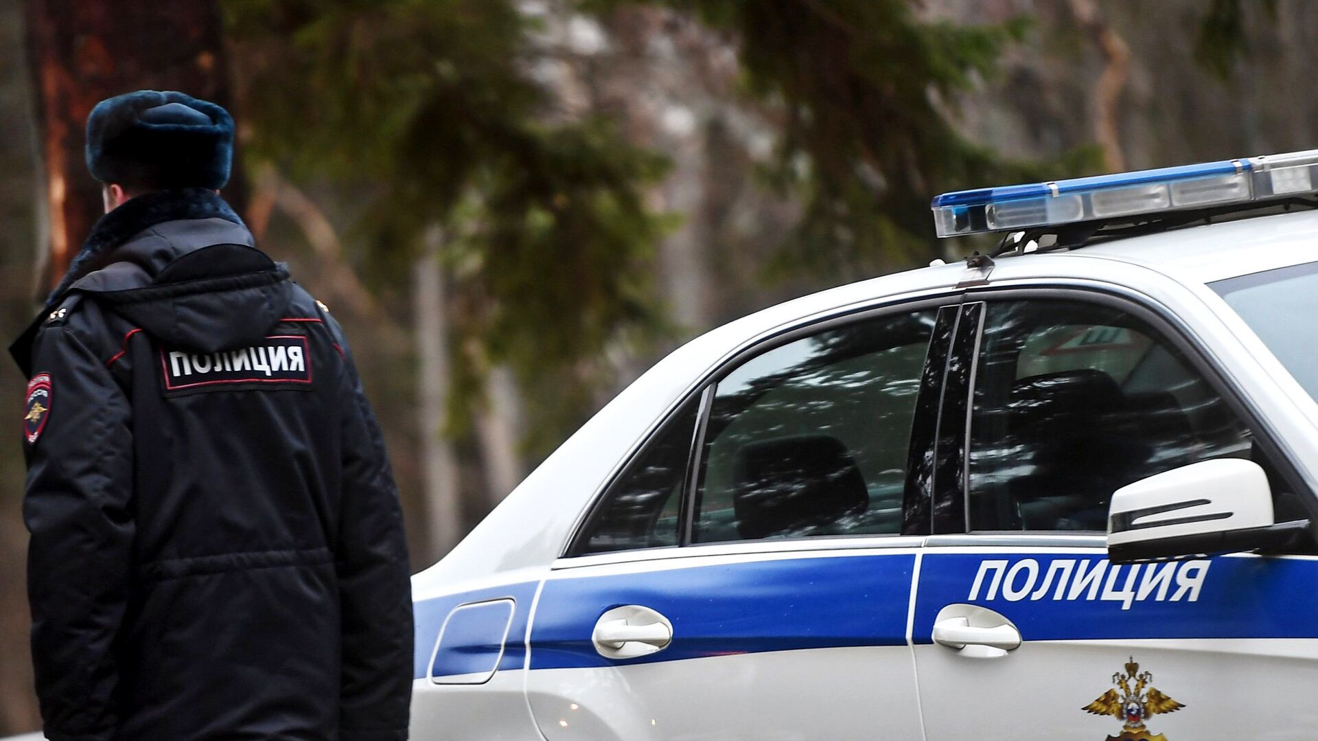 Сотрудник полиции возле служебного автомобиля - РИА Новости, 1920, 04.12.2023