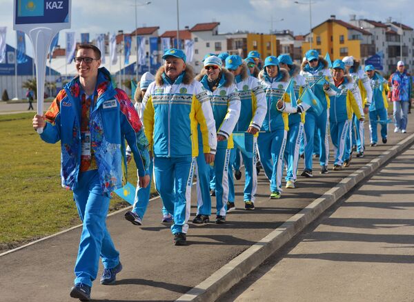 Волонтер сопровождает казахскую делегацию в прибрежной Олимпийской деревне в Сочи