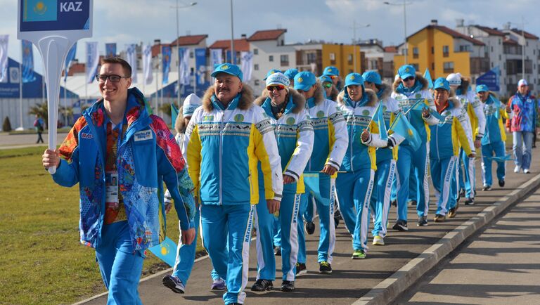 Волонтер сопровождает казахскую делегацию в прибрежной Олимпийской деревне в Сочи
