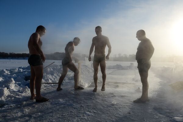 Спортсмены клуба закаливания и зимнего плавания во время купания в проруби на озере в Ленинском районе Новосибирска