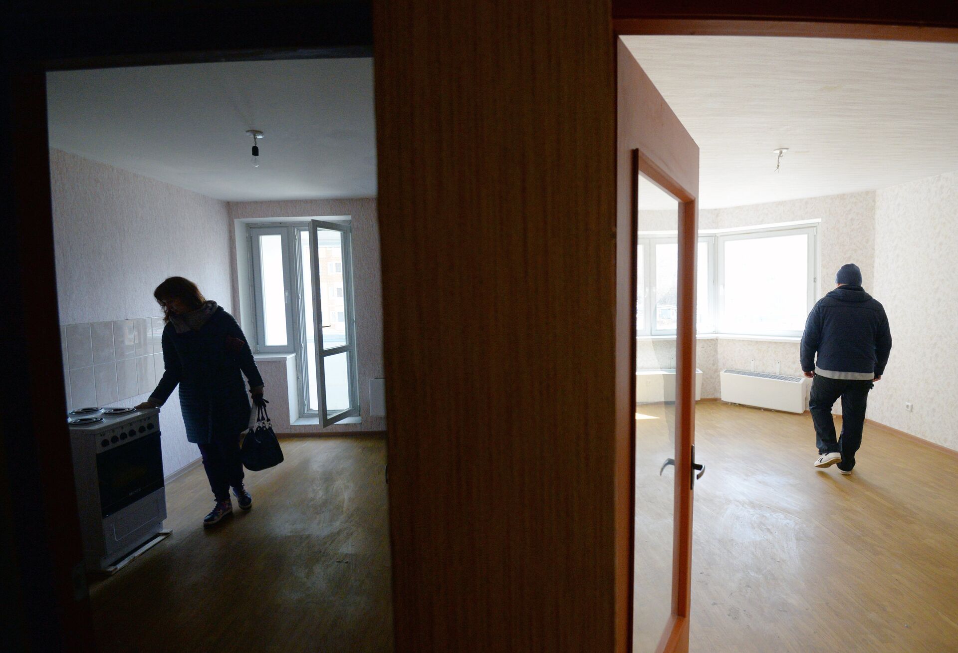 Мужчина и женщина осматривают свою квартиру в новом жилом доме - РИА Новости, 1920, 07.10.2021