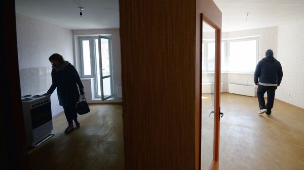 Мужчина и женщина осматривают свою квартиру в новом жилом доме