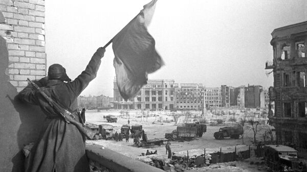 Красный флаг над площадью Павших борцов, освобожденного Сталинграда. На заднем плане — здание универмага, где был взят в плен штаб окруженной 6-й армии вермахта во главе с командующим армией фельдмаршалом Паулюсом.