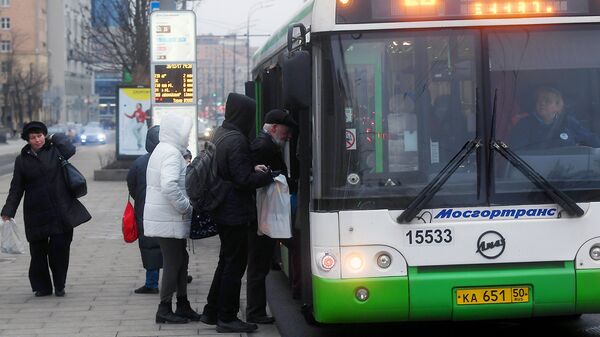 Пассажиры садятся в автобус на одной из улиц в Москве. Архивное фото
