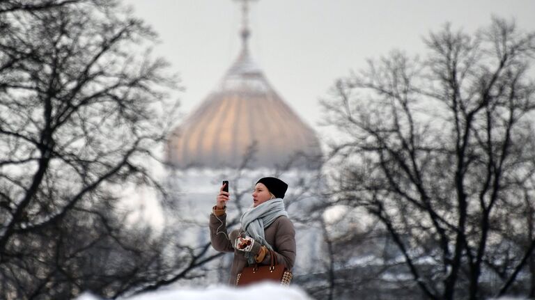 Девушка фотографируется в Александровском саду в Москве