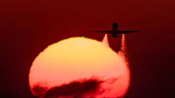Самолет Airbus A-321 на фоне закатного солнца