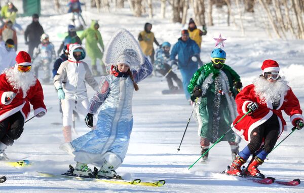 Участники массового спуска в карнавальных костюмах с горы Морозной на фестивале снега и зимних видов спорта Морозная FEST в Камчатском крае