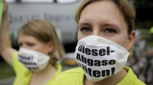 Протестующие в масках с надписью Kill diesel emissions в Берлине