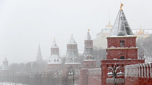 Автомобили на Кремлевской набережной в Москве во время снегопада
