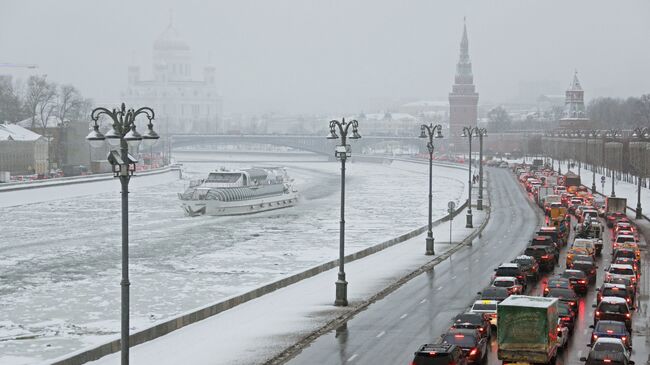 Автомобили на Кремлевской набережной в Москве во время снегопада. Архивное фото