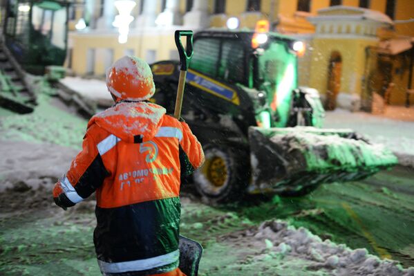 Сотрудники коммунальных служб убирают снег на улице в Москве. 31 января 2018