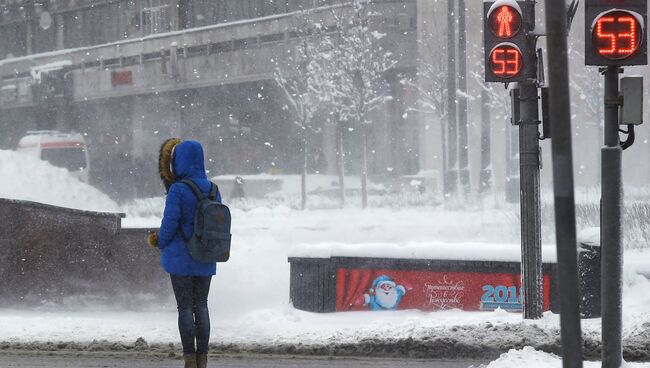 Девушка у пешеходного перехода на одной из улиц в Москве. архивное фото