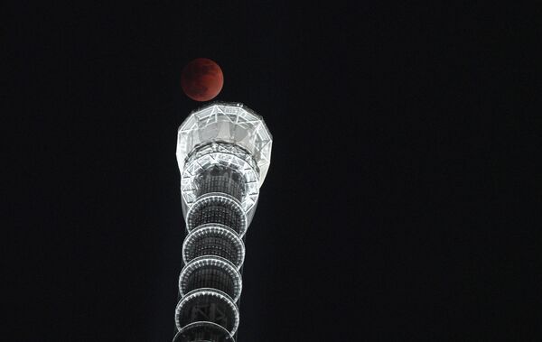 Полная луна на фоне башни Sky Tree в Токио