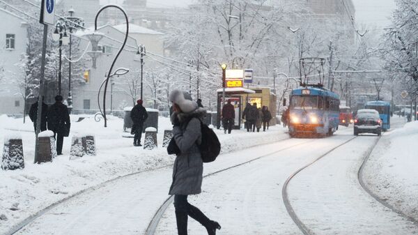 Девушка переходит трамвайные пути у остановки Метро Новокузнецкая в Москве