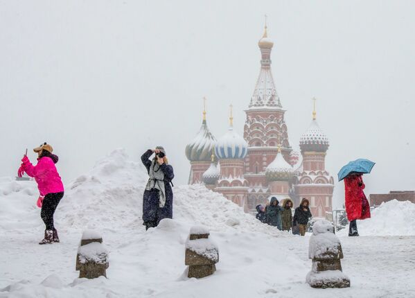 Туристы фотографируются перед собором Василия Блаженного на Красной площади в Москве. 31 января 2018 года