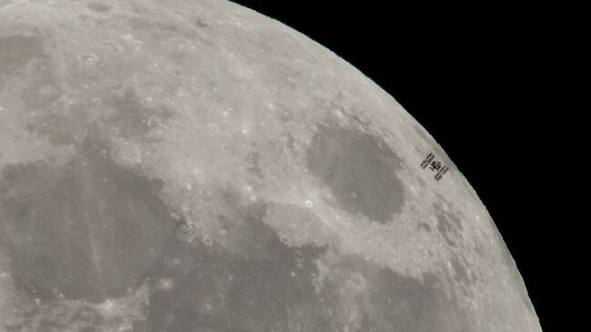 Международная космическая станция пролетает мимо Луны во время полнолуния. Архивное фото