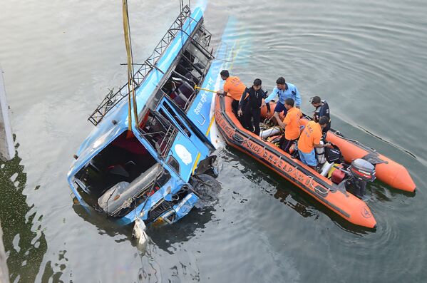 Индийские спасатели и полицейские на месте падения в реку рейсового автобуса в штате Западная Бенгалия на северо-востоке Индии. 29 января 2018 года