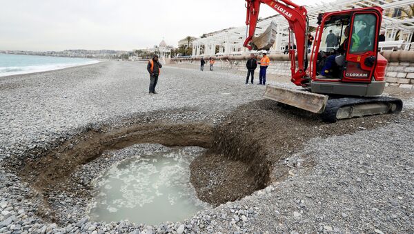 Экскаватор рядом с пятиметровым кратером, который сформировался на пляже Лидо в Ницце, Франция. 1 февраля 201