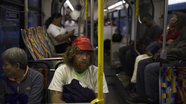 Бездомный в кепке с надписью Сделаем Америку снова великой в автобусе в Лос-Анджелесе