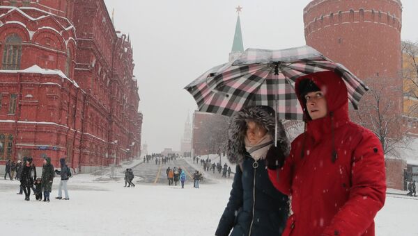 Прохожие на Манежной площади во время снегопада в Москве. Архивное фото