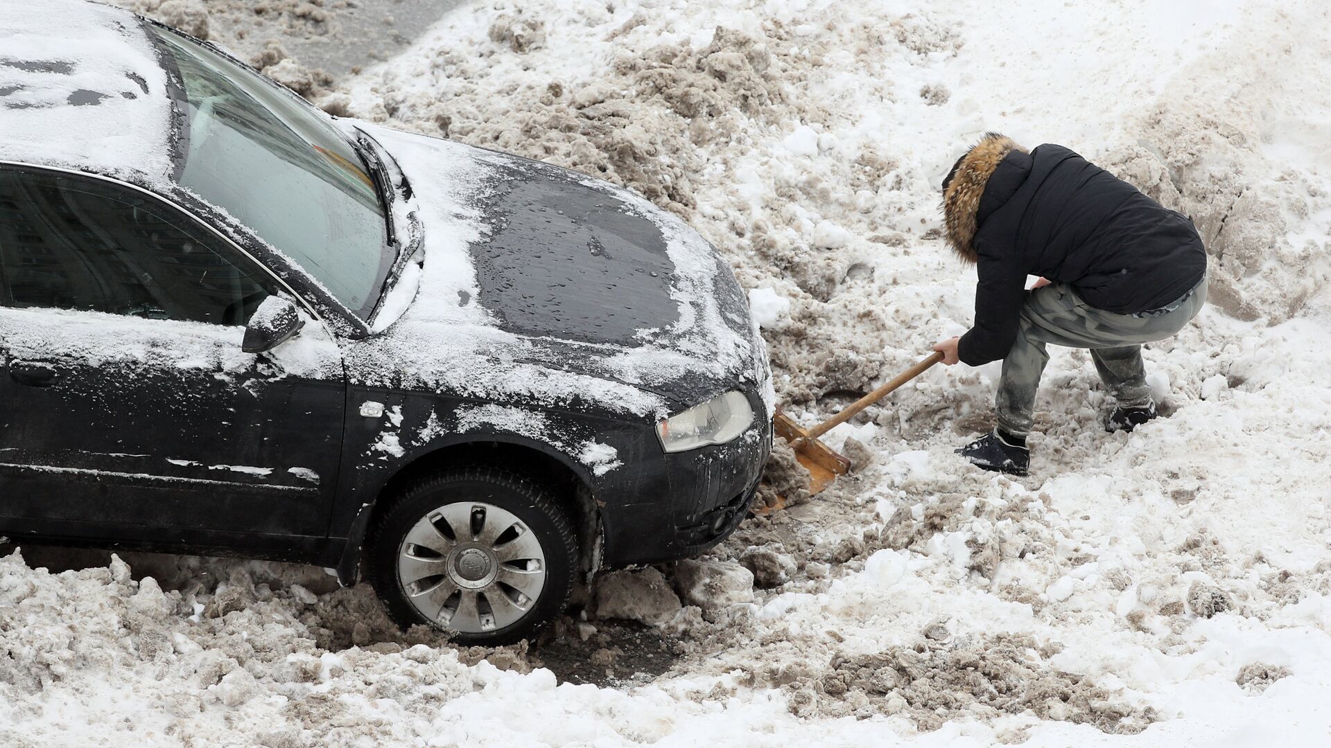 Водитель откапывает из снега свою машину после снегопада - РИА Новости, 1920, 17.01.2021