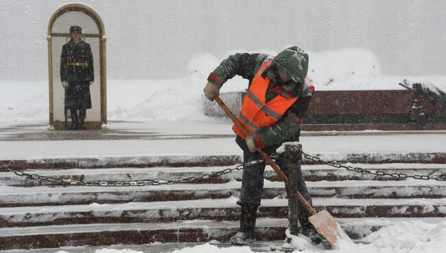 Сотрудник коммунальных служб убирает снег возле Вечного огня на Могиле Неизвестного Солдата у стен Московского Кремля. 4 февраля 2018