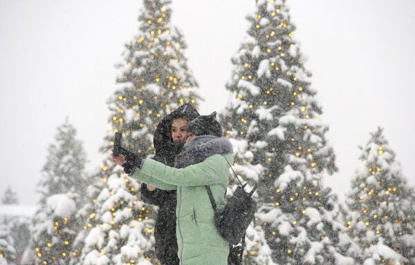 Девушки фотографируются во время снегопада на Манежной площади в Москве. 4 февраля 2018