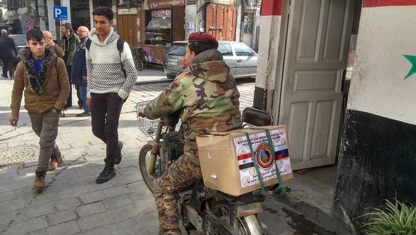 Житель Дамаска с коробкой гумпомощи из России. Архивное фото