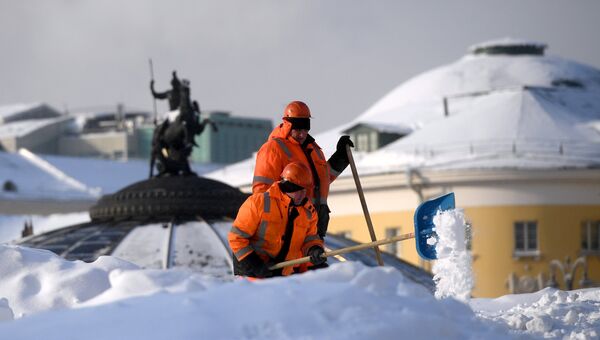 Сотрудники коммунальных служб убирают снег на Манежной площади в Москве. Архивное фото