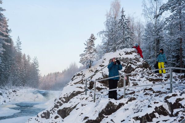 Туристы у водопада Кивач, образуемого падением реки Суны, на территории Государственного заповедника Кивач в Республике Карелия