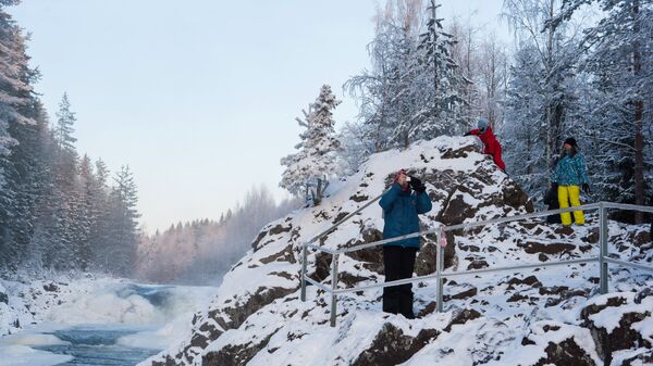 Туристы у водопада Кивач, образуемого падением реки Суны, на территории Государственного заповедника Кивач в Республике Карелия