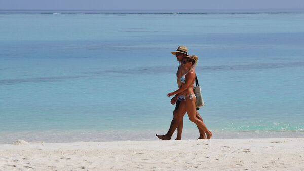 Пара гуляет по пляжу на одном из Мальдивских островов