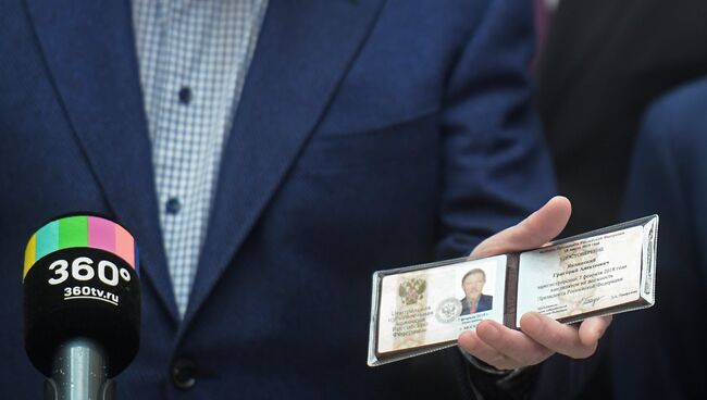 Кандидат в президенты РФ от партии Яблоко Григорий Явлинский демонстрирует удостоверение после регистрации в Центральной избирательной комиссии РФ. 7 февраля 2018