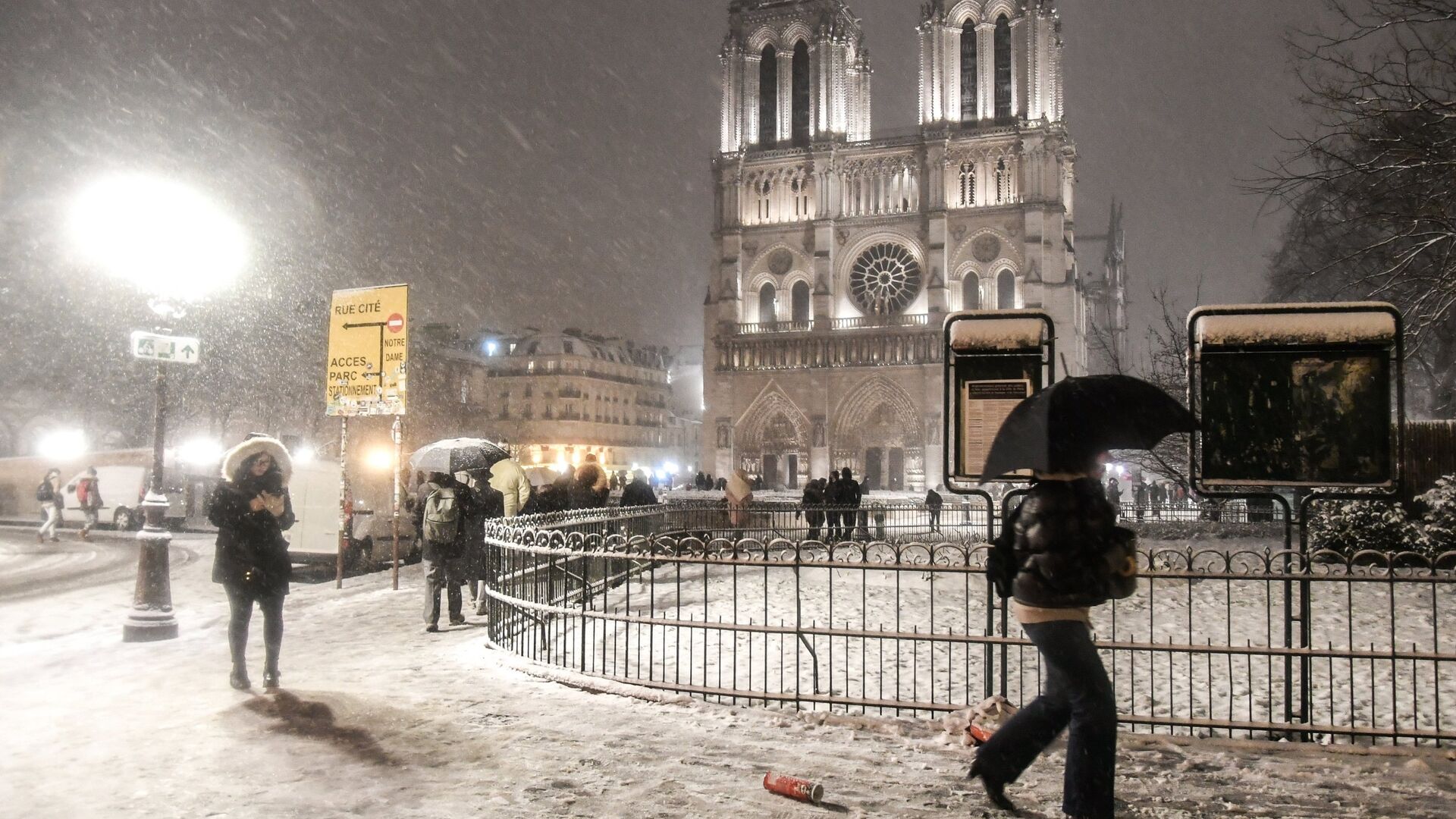 Прохожие возле собора Парижской Богоматери (Notre-Dame de Paris) во время снегопада в Париже - РИА Новости, 1920, 27.12.2020