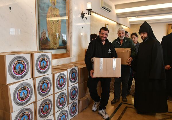 Участники межконфессиональной делегации религиозных деятелей из России во время раздачи гуманитарной помощи для сирийских беженцев в греко-католической церкви в ливанском городе Захия