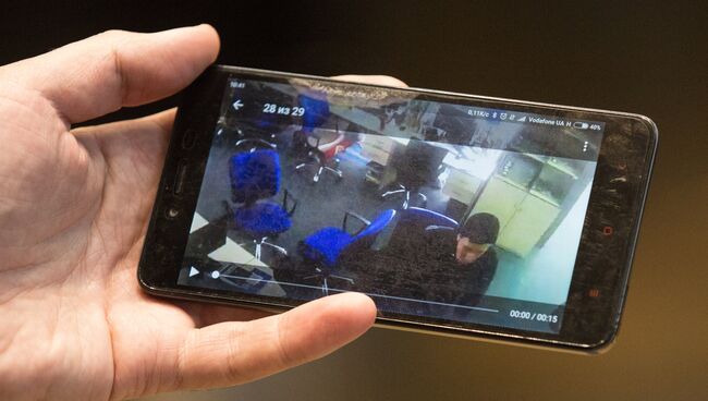 Человек смотрит на смартфоне трансляцию с камер наблюдения редакции газеты Вести, где проходят обыски. 8 февраля 2018