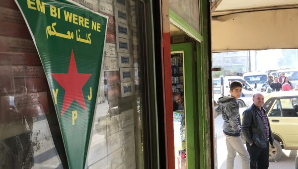 Флаг курдских сил самообороны (YPJ) на центральной улице города Африн, Сирия
