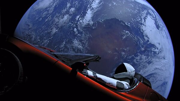 Личный автомобиль главы SpaceX Илона Маска красный кабриолет Tesla Roadster, выведенный на орбиту ракето-носителем Falcon Heavy американской компании SpaceX, с манекеном в скафандре за рулем в космическом пространстве