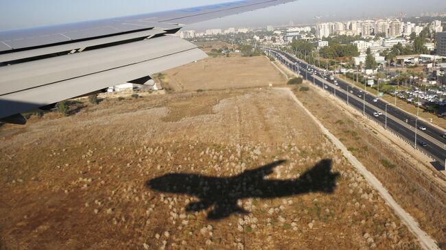 Тень от самолета, прилетающего в международный аэропорт Бен-Гурион в Тель-Авиве, Израиль