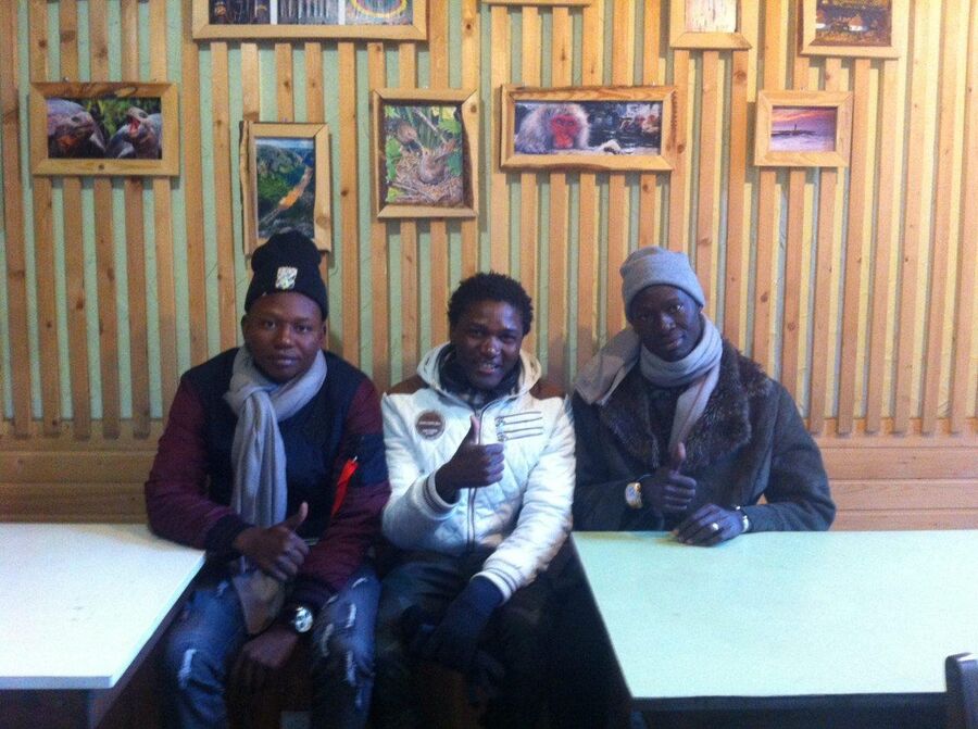 Музыкант Kolossus Kelevra из Кении (в центре) со своими друзьями, постояльцами хостела