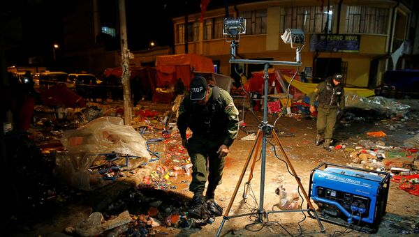Полицейские проверяют место взрыва бутылки с газом во время парада карнавала в Оруро, Боливия. 10 февраля 2018