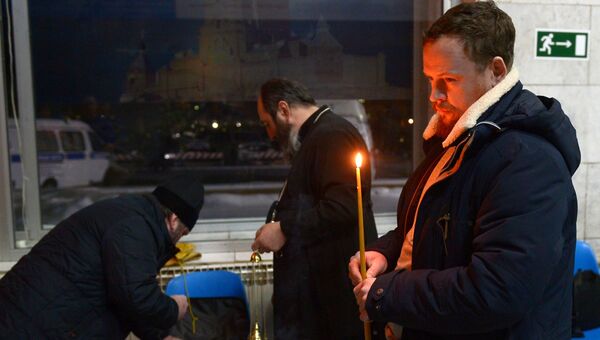 Мужчина ставит свечу в аэропорту Орска в память о пассажирах, погибших в результате крушения самолета Ан-148. 12 февраля 2018