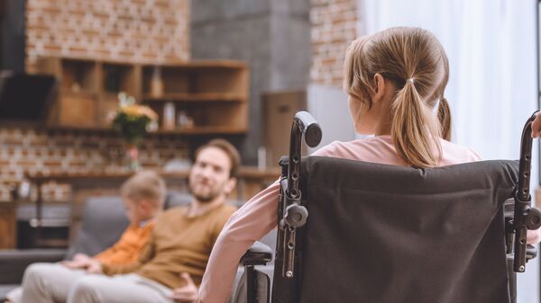 Девочка в инвалидном кресле дома
