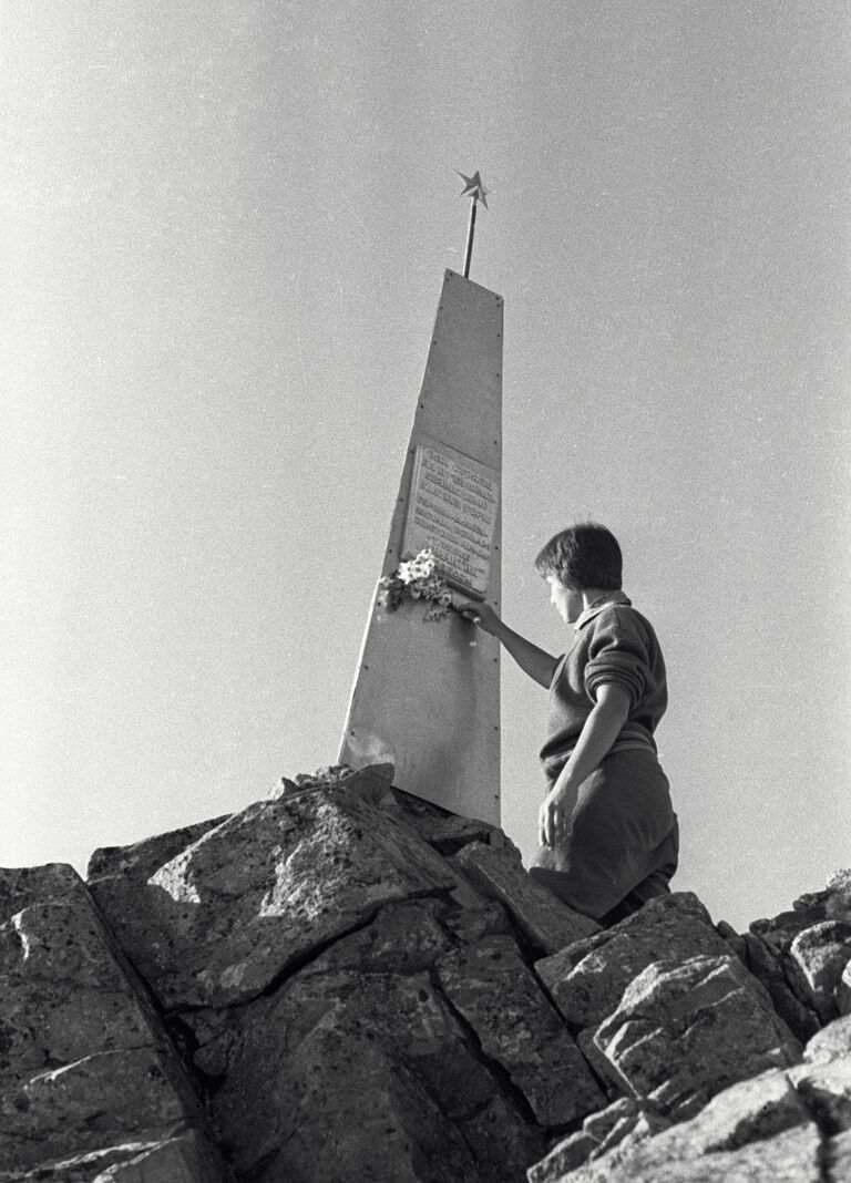 Женщина возлагает цветы к памятнику советским воинам на перевале Донгузорун Женщина возлагает цветы к памятнику советским воинам на перевале Донгузорун