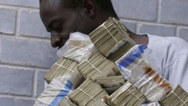 Мужчина несет пачки денег в Хараре, Зимбабве. 5 марта 2008