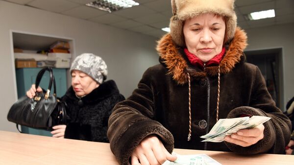 Женщина пересчитывает полученную пенсию на почтамте. Архивное фото