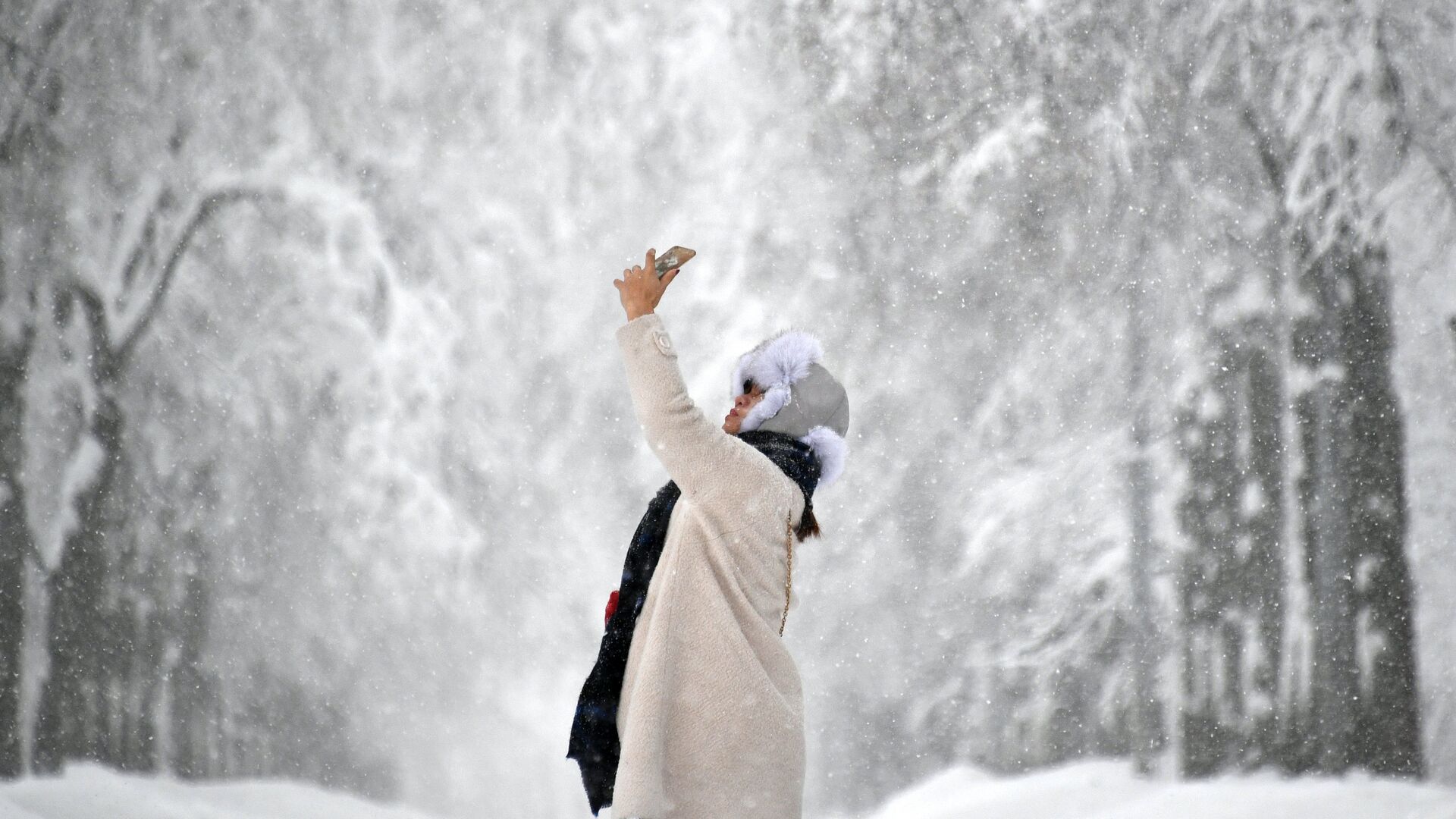 Девушка фотографируется во время снегопада - РИА Новости, 1920, 21.02.2021