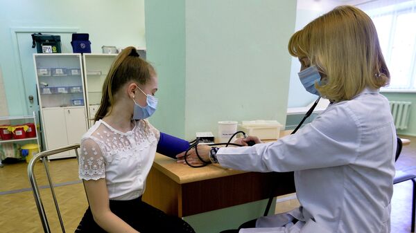 Врач осматривает пациента в целях профилактики заболевания гриппом и ОРВИ. Архивное фото